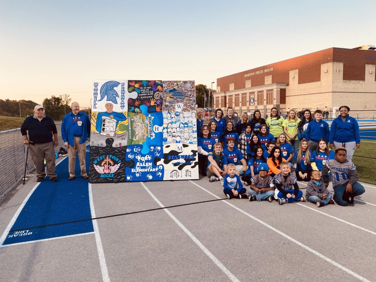 Alumni of Project 18 and representatives from each building surrounded the puzzle to symbolize all schools in our district coming together as one.