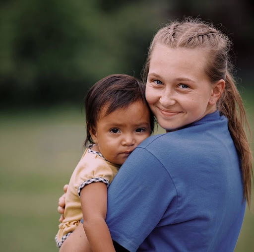 Melanie hold a little girl for a picture.